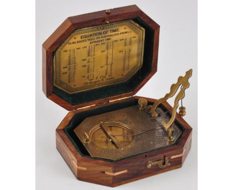 A brass sundial and compass cased in a wooden box