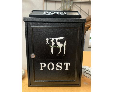 A BLACK WALL HANGING POST BOX WITH A FRESIAN CALF DESIGN 