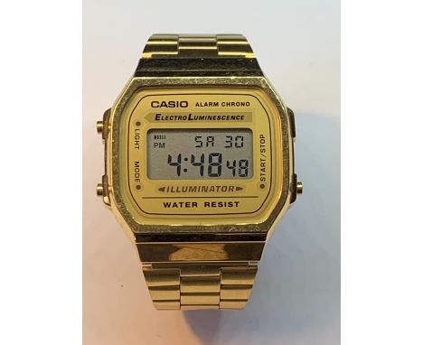 A RETRO CASIO ILLUMINATOR DIGITAL WRIST WATCH WITH YELLOW METAL STRAP SEEN WORKING BUT NO WARRANTY 