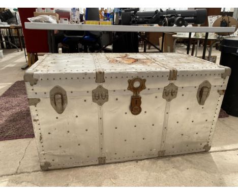 A VINTAGE ALLOY COVERED TRAVEL TRUNK WITH CLASPS AND LEATHER CARRY HANDLES 