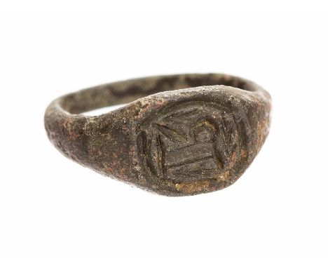 A complete cast copper-alloy finger ring dating to the Late Medieval period, c. 1400-1500. The ring is a signet type, demonst