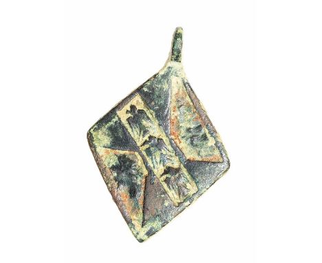 A complete cast copper-alloy and enamel heraldic harness pendant dating to the Medieval period, c. 1200-1400. It is lozenge-s
