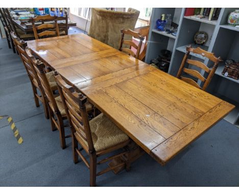 A modern oak extending refectory dining table having an extra leaf, 75.5cm h x 239.5cm w, together with sx ladder back and ru