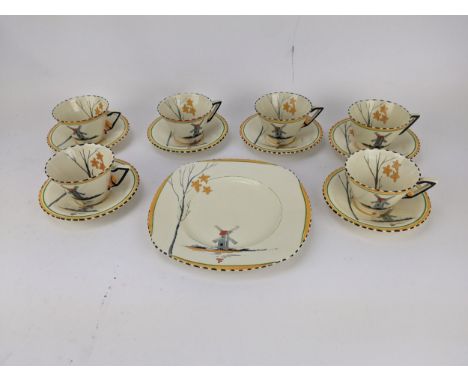 A Zenith Art Deco china tea set decorated with a windmill by a lake and tree comprising six cups, six saucers and a tea cake 