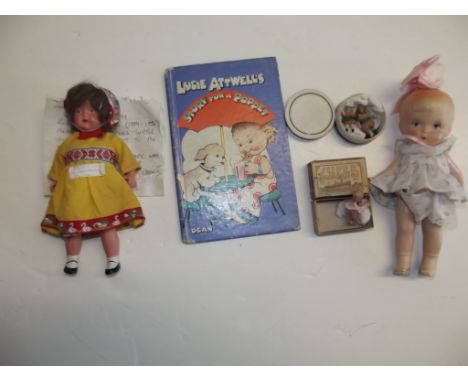 A group of small dolls, a very tiny Kewpie in a matchbox, two tiny porcelain dolls in a box, a pottery doll, a plastic doll, 