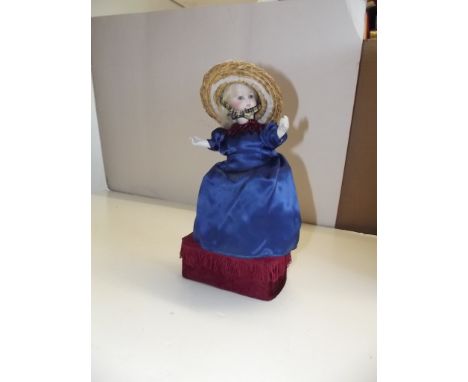 An early 20th century French automaton, the doll with porcelain head and arms on a composite body, the base with a musical mo