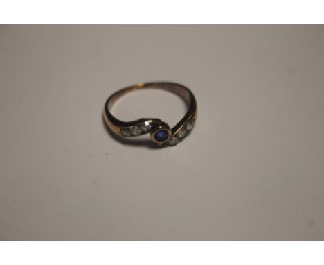 A YELLOW METAL DRESS RING, SET WITH A CENTRAL SAPHIRE (CHIPPED) FLANKED BY 6 SMALL DIAMONDS
