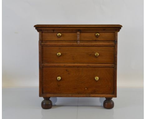 An oak commode chest, having two over two drawers with brass handles on squat feet, 50cm x 41cm x 50cm high