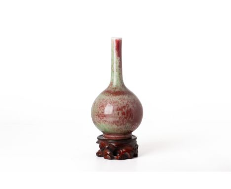 A PEACHBLOOM GLAZED PORCELAIN BOTTLE VASE
With green and red mottled glaze, bears Kangxi six character mark within a double c