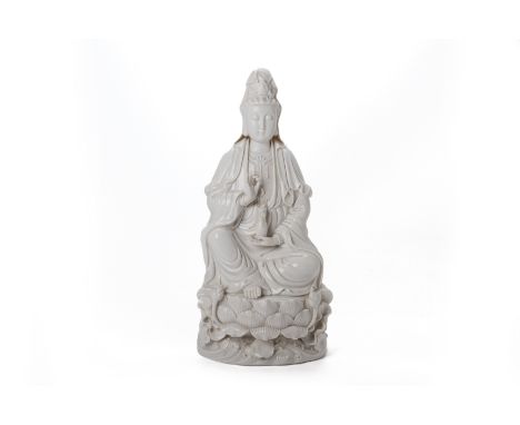 A LARGE BLANC DE CHINE PORCELAIN FIGURE OF GUANYIN
Modelled seated on a lotus base, and holding a pearl and vase, relief moul