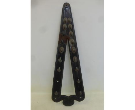 An original cast iron tool rack with brass hooks, made by Carter's of Salford.