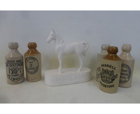 A selection of stoneware ginger beer bottles and a White Horse Scotch Whisky advertising horse figure.