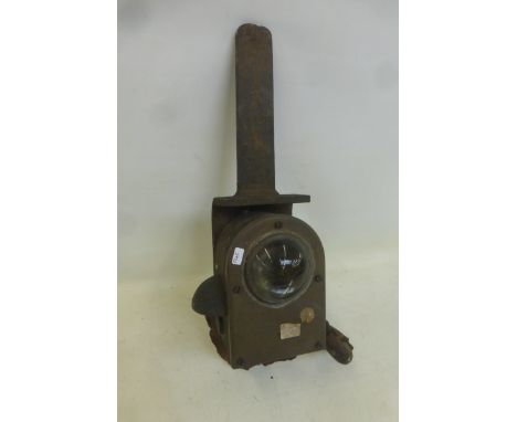 A brass fronted lamp with bullseye lens and switch to the side.