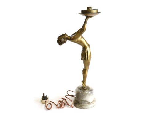 An Art Deco Gilt Patinated Spelter Figural Lamp, modelled as a semi nude on tip toes, wearing a short skirt, on a grey onyx b