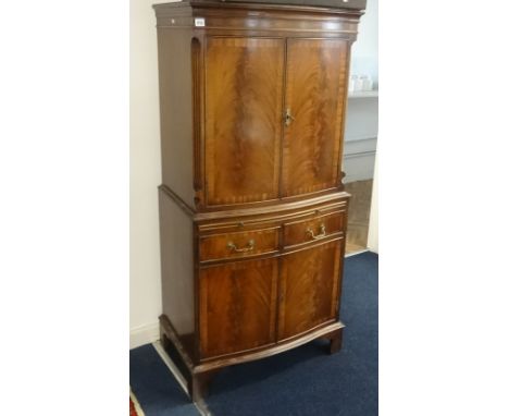 A Reproduction mahogany cocktail cabinet made by Bevan &amp; Funnell Ltd with a light, glass shelves and maple lined interior