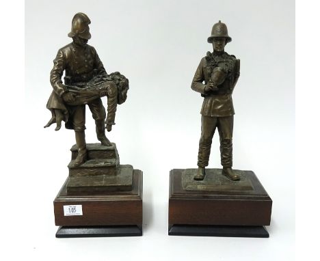 A pair of bronze effect fire fighting figures on wood plinth, height 73cm.