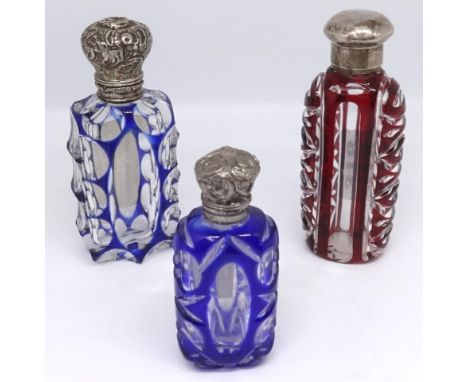 A Victorian blue overlay glass scent bottle with a silver top, a continental blue glass scent bottle and a Victorian ruby gla
