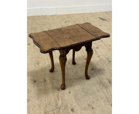 A burr walnut low lamp table with twin drop flaps, on cabriole supports (h.46cm x l. (open) 65cm x w.36cm)