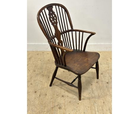 An early 19thc elm comb back open armchair with pierced splat and saddle seat (h.95cm x l.56cm x w.50cm)