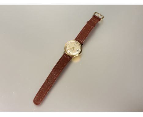 A gents 18ct gold Precimax manual wind wirst watch with silvered dial and baton hour markers with date apeture complication s