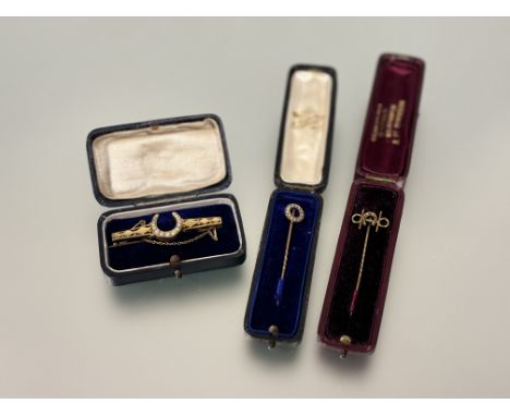 A group of Edwardian jewellery to include a 15ct gold seed pearl stick pin: 1.49g, a yellow metal horseshoe stick pin: 0.95g 