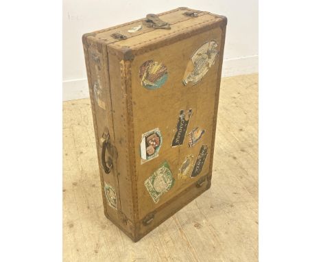 A vintage 1920s/30s travel trunk of compressed board, with metal bound edges with a variety of orignal vintage travel labels 