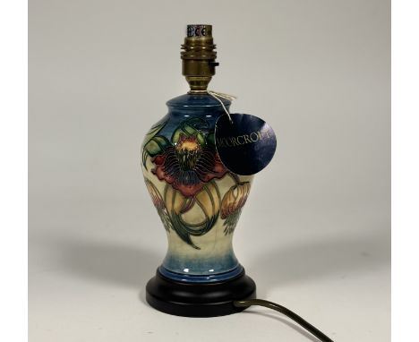 A Moorecroft Pottery Ann Lily pattern table lamp raised on a circular wooden base with Moorcroft tag. (h-15cm)