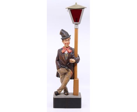 A mid-20th century, polychromed wood whistling tramp with moving head automaton, standing beside a lamp post with metal lante