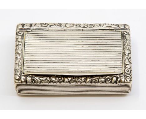 A George III silver snuff box, the body and cover chased with ridged decoration, the top section with foliate border, marked 