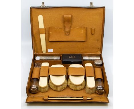 A George V leather Gentleman's travelling case, fitted interior to include four ivory mounted brushes, comb and shoe horn, a 