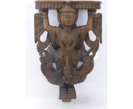 A Teak Siamese Wall Mounted Shelf, depicting a winged deity, approx 48 x 29 cms.