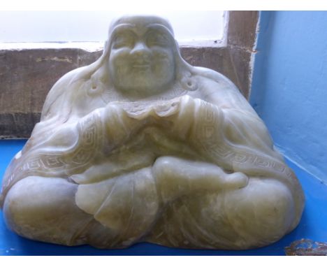 An Antique Chinese Celadon Green Buddha, carved from a single boulder, Buddha depicted seated with an expression of serenity,