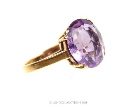 A 9 ct, yellow gold, Edwardian, large amethyst ring, the central, large, natural, oval-shaped, faceted stone claw set to soli