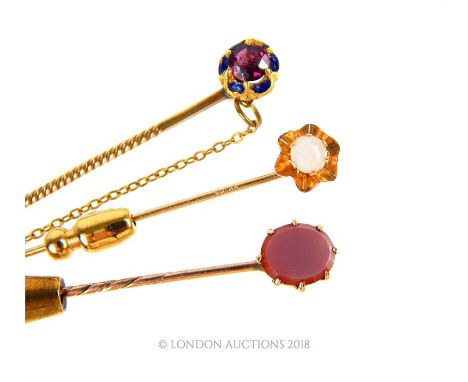 Three, 9 ct yellow gold, tie pins to include a garnet and blue enamelled example (6.3 cm), a oval-shaped polished carnelian e