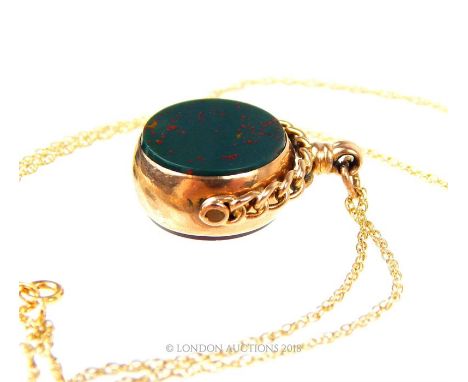 A 9 ct yellow gold, vintage, revolving fob pendant in set with two circular panels of bloodstone and carnelian to a yellow go