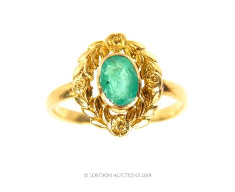 An 18 ct yellow gold, late 19th century, emerald and carved gold ring, a central oval-shaped, gold frame carved with a garlan