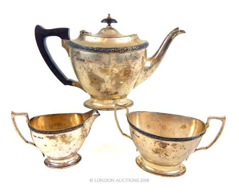 A sterling silver three piece tea set, James Dixon & Sons Ltd, Sheffield 1945, having a decorative border to the rim, the tea