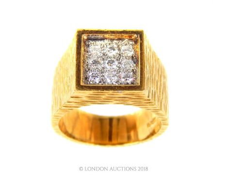 An 18 ct yellow, textured gold ring set with nine brilliant cut diamonds in a square formation, to wide textured shoulders an