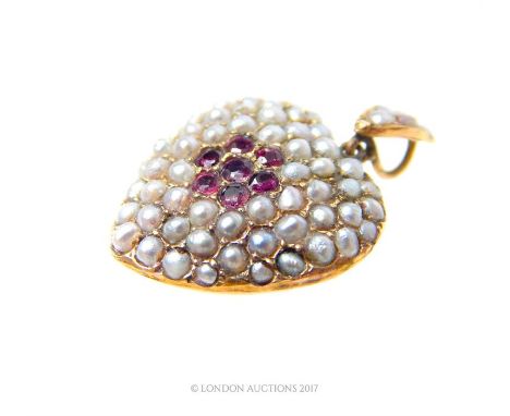 An antique, French, 9 ct yellow gold, ruby and seed pearl studded heart-shaped pendant, centrally set with a flower-head moti