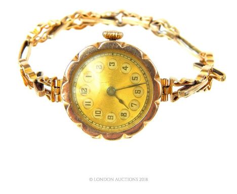 A vintage, 9 ct yellow gold wristwatch, the case in the form of a twelve-petalled flower head with the gilt dial set with bla