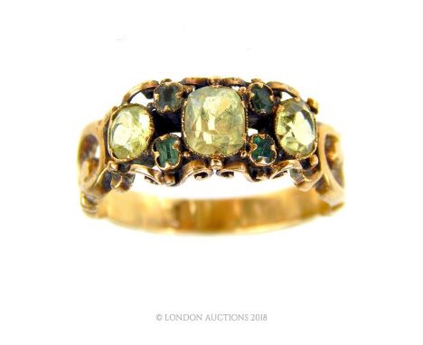 A 9 ct, antique yellow gold, citrine and emerald ring, composed of three, graduated clear green citrines (5 x 4 mm) and four 