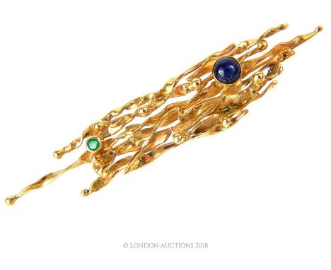 An 18 ct yellow gold, vintage cabochon sapphire and faceted emerald brooch in the style of Andrew Grima, 7 x 1.5 cm, Weight: 