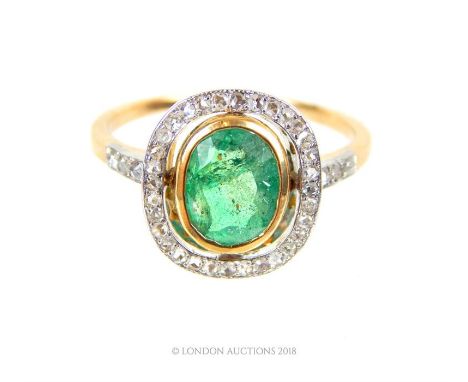 An 18 ct yellow gold and platinum, Art Deco, emerald and diamond cluster ring, a central, bezel-set, oval shaped, faceted, na