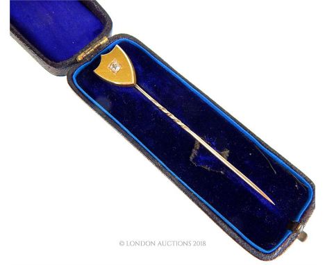 A high ct, yellow gold, antique, shield-shaped, stick pin set with a central, old cut diamond (3 x 3 mm), Shield: 17 x 14 mm,