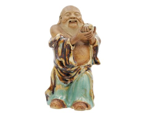 A Chinese pottery and flambe glazed model of Buddha, 19th century. Height 15cm, width 7cm, depth 6cm.
