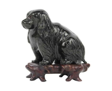 A Chinese carved jade model of a dog. On original wooden stand, total height 10cm, width 10cm, depth 6cm.