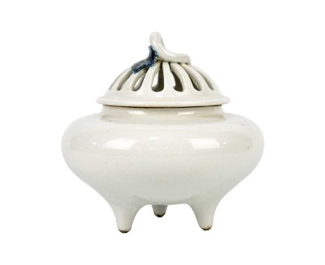 A Chinese blanc de chine crackle-glazed tripod censer, 19th century. The pierced cover with a blue glazed leaf, height 15cm, 