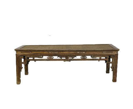 A Chinese hardwood Kang table, early 20th century. The rattan covered top, above a pierced frieze on square section legs, hei