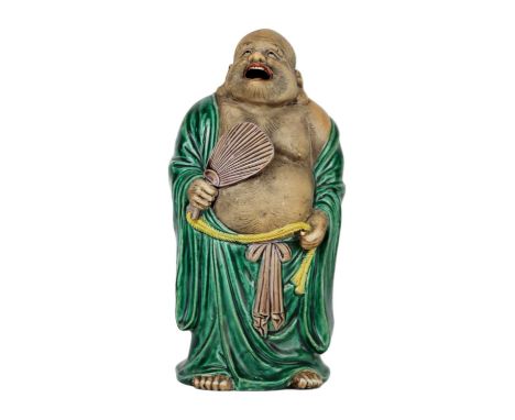 A Japanese Kutani porcelain model of Hotei, Meiji period. Standing and holding a fan in his right hand, height 24cm, width 10