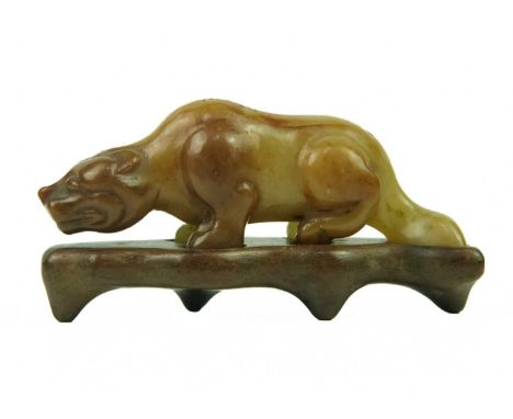 A Chinese russet jade tiger, Qing Dynasty, 19th century. Height 3cm, length 7.3cm, depth 2cm, on a fitted wood stand, height 